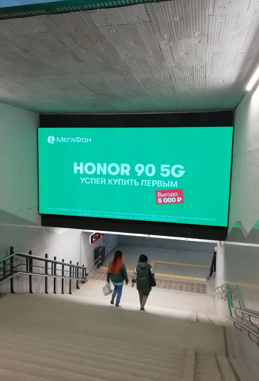 Большой LED-экран с рекламой HONOR над эскалатором